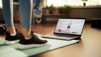 Woman Workout, Watching Trainer on Laptop, via Online Video Tutorial while Virtual Training at...