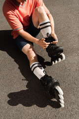 Cropped view of man in shorts wearing roller blades on asphalt.