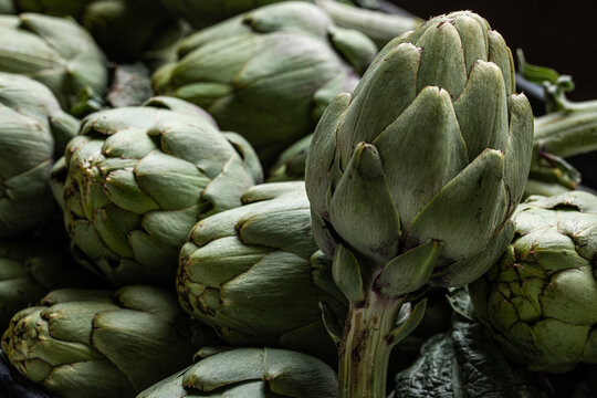 Collection of fresh artichokes in market