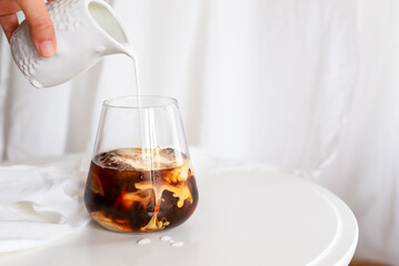 cold brew coffee with milk on white wooden table