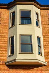 Visible bay window or half turret or spire style outlet with beige stucco exterior and wooden facade of house or home building