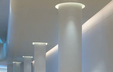 Concrete interior space with white round pillars arranged long lines lighting cast the shadow on...