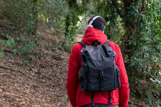 Anonymous male traveler walking in forest