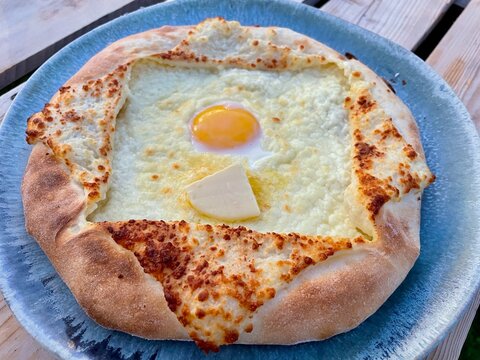 Adjarian Khachapuri on blue ceramic plate.