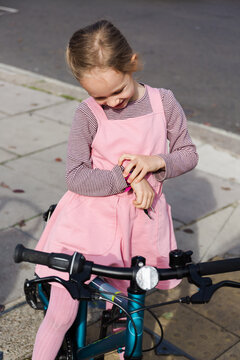 Girl on bicycle checking time
