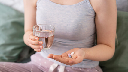 Woman holding pill in hand with water.Health concept 
