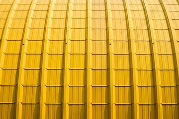 Yellow Curved Corrugated Steel Roof Background with sunlight on surface