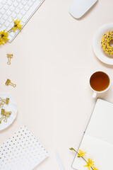 Concept of a workspace for female bloggers. Keyboard, notepad, pen, cup of tea, don't, yellow flowers Copy space, flat lay, top view.