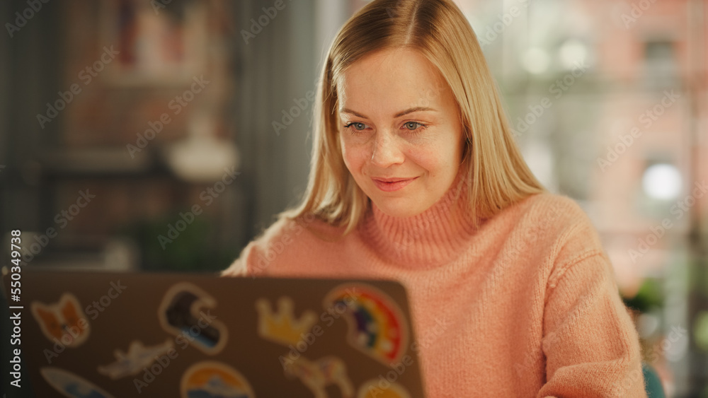 Poster attractive young woman working on laptop computer while sitting in stylish cozy creative office. fre