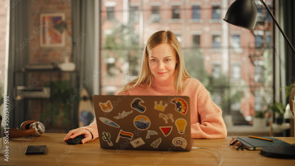 Poster beautiful young woman working on laptop computer while sitting in stylish cozy creative office. free