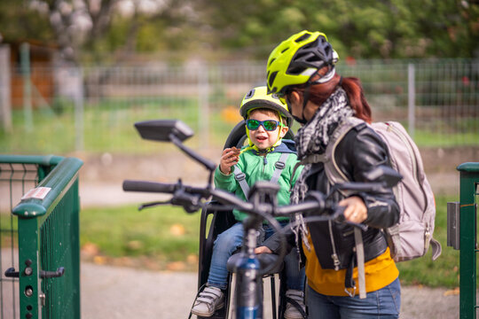 Boy sitting in baby bike seat during ride with mother
