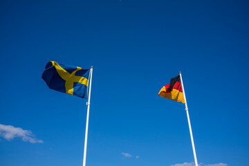 the german and swedish flags are waving in the wind