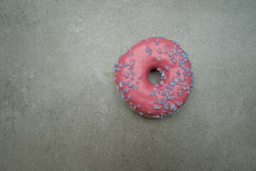 Pink sweet donut on the grey table