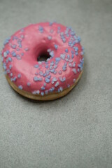 Pink sweet donut on the grey table