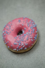 Pink sweet donut on the grey table