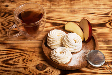 Fototapeta na wymiar Handmade marshmallow. Natural sweetness. Apple zephir and cup of tea in wood surface