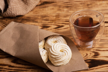 Handmade marshmallow. Natural sweetness. Apple zephir and cup of tea in wood surface