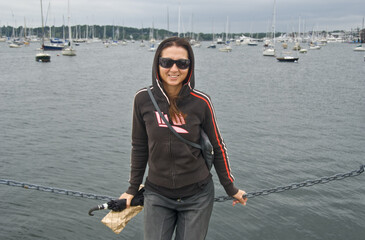 Happy beautiful brunette caucasian girl visiting Mystic Port in Connecticut, USA