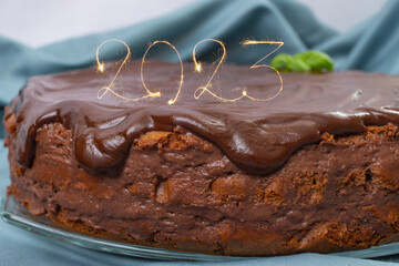 2023 written with sparks on a chocolate cake,