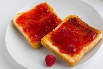 Toasts with raspberry jam on white plate
