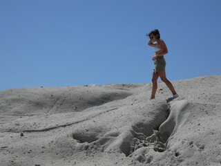 young curly-haired woman in a lunar landscape. Cane Malu, Sardinia.