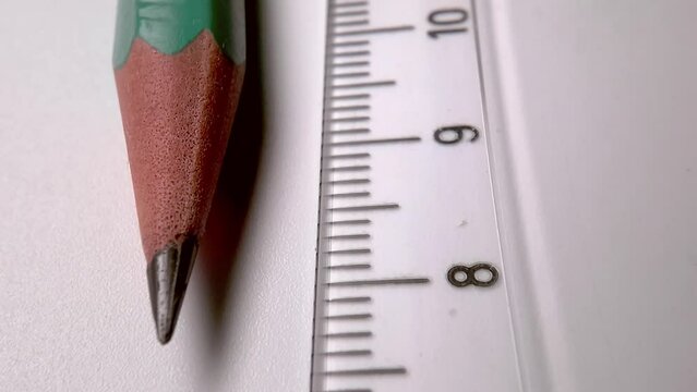 plastic transparent ruler and wooden slate pencil on a white table. Desktop in the office.