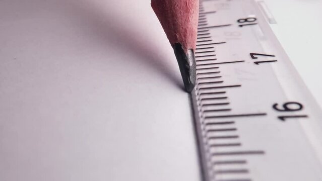 Drawing with pencil and ruler on white drawing paper. Desktop in the office.