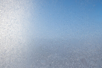 Ice freezes on glass in the cold winter season. Frosty original pattern on winter window glass, natural texture. copy space