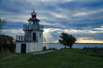 Fototapeta na wymiar Lighthouse, Spodsbjerg Fyr in Huntsted on the coast of Denmark. Sun rays shining