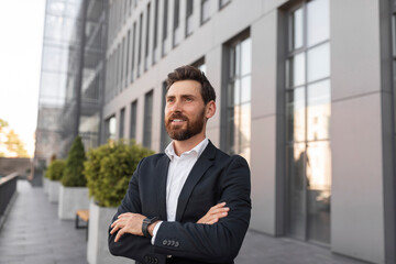 Confident cheerful young european man ceo manager with beard crossed arms over chest and looks at empty space