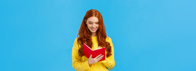 Waist-up portrait redhead female student write down thoughts in red lovely notebook, prepare...