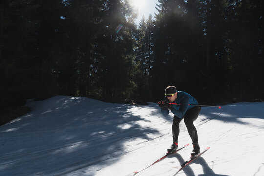 Nordic skiing or Cross-country skiing classic technique practiced by man in a beautiful panoramic trail at morning.