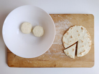 Piadina ready to be tasted on a cutting board with two flour dough. Typical italian dish concept. Top view, flat lay.