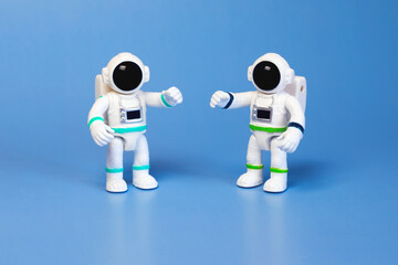 Plastic figurines of an astronauts in a spacesuit on a blue background. Children's toys astronauts. Fascination with space, the study of planets.