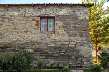 Part of the decoration of the facade of the building and the material from which it is built;  
old stone house and window