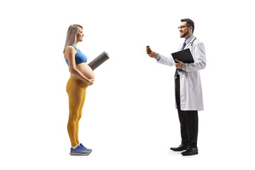 Full length profile shot of a doctor giving a bottle of vitamins to a pregnant woman in sportswear