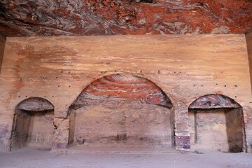 Interior of an ancient tomb in Petra, Jordan. Colorful sooty walls and ceiling of tomb. Petra is...