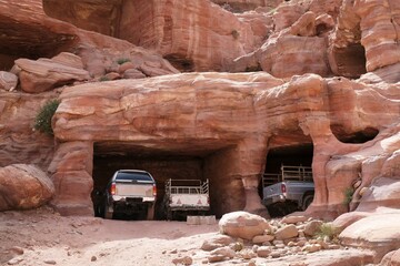 Cars standing in rooms carved in rocks in Petra, Jordan. Petra is ancient Nabataean city,...