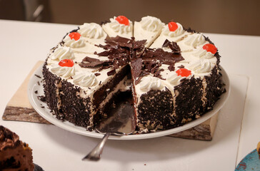 Eine angeschnittene Schoko Creme Torte bei der schon Stücke fehlen.