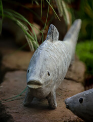 Die Skulptur, Figur eines Fisches am Rand meines Goldfischteichs.
