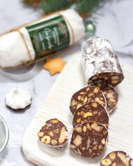 Chocolate sausage on a white wooden board, background in soft focus, holiday atmosphere