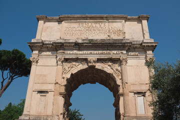 Fototapeta na wymiar Rome, Italy - Arch of Titus ruins along the Via Sacra in the Roman Forum. Ancient structure celebrating fall of Jerusalem. Symbol of Jewish diaspora. Inspiration for Arc de Triomphe. Famous landmark.