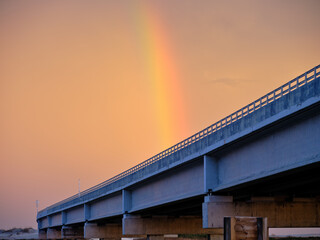 Obraz premium Colorful Rainbow at sunset over the Herbert C Bonner new bridge over Oregon Inlet on the Outer Banks of North Carolina