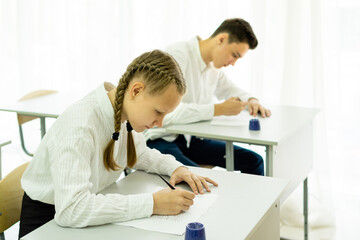 Male And Female Teenage Students Studying In Classroom. High quality photo