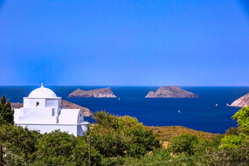 Fototapeta na wymiar Traditional chapel with sailing boats at the background, in Milos island, Cyclades, Greece