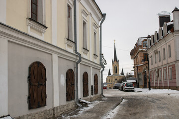Fototapeta na wymiar Architecture old medieval town Lutsk Ukraine. Winter view on old city paving stone street and history buildings. National landmark in snow. Tourist famous attraction.
