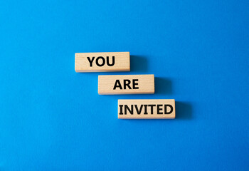 You are invited symbol. Wooden blocks with words You are invited. Beautiful blue background. Business and You are invited concept. Copy space.