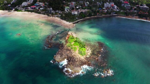 Parrot Rock Hill washed by Indian ocean waves flying drone beautiful Nature's landmark 4K video in Mirissa, Matara District on Sri Lanka. Exotic Asian countries and around the World traveling concept
