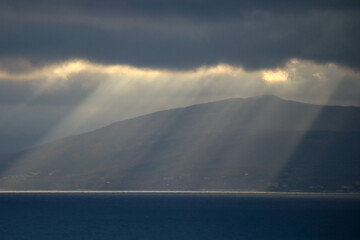 Fototapeta na wymiar the sun rays shine through the clouds on the sea surface
