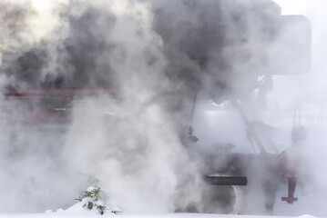 A steam locomotive completely swathed in steam.